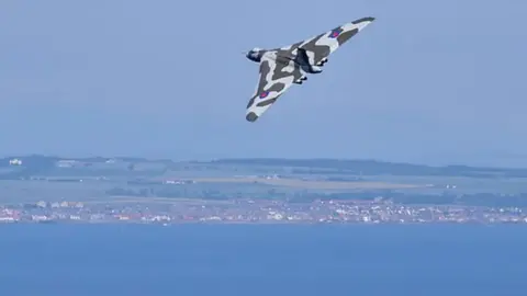 Walter Baxter/Geograph XH558 flying over a seaside town