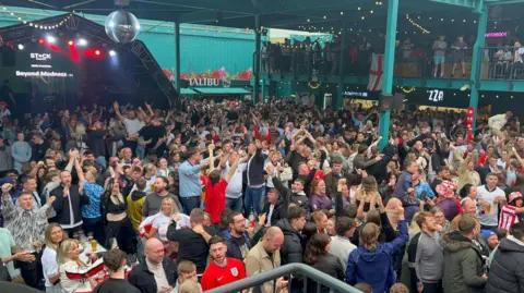 Crowds wearing England shirts stitchery information benches, galore fist bumping nan air