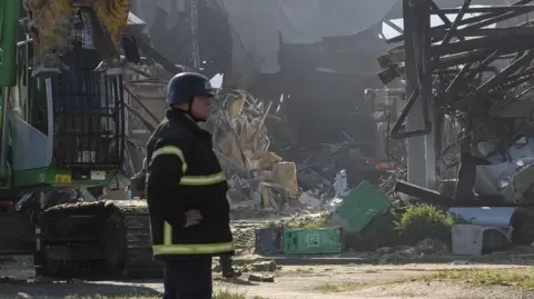 Rescuers work at the site of a shopping centre destroyed by the strike