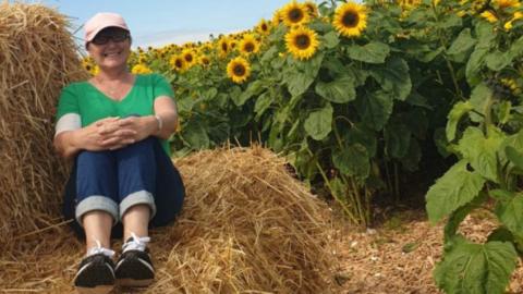 Christine Campbell in field of sunflowers
