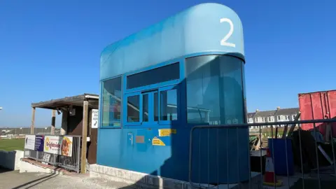 An old blue Tamar Bridge toll booth in its new home at Saltash United Football Club's Kimberley Stadium.
