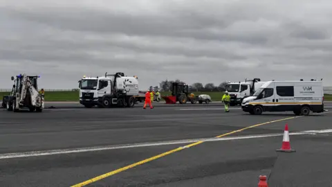 Multiple vehicles on the runway at East Midlands Airport