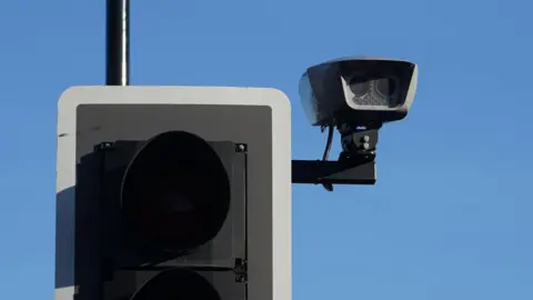 A traffic light with a small ANPR camera attached