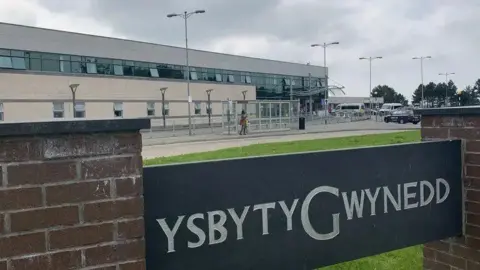 BBC The Ysbyty Gwynedd sign outside the hospital in Bangor.