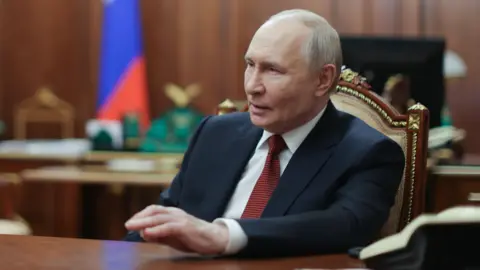 Putin sat at a desk