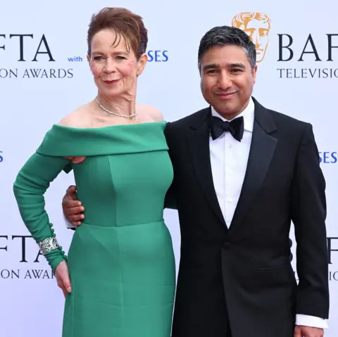 Getty Images Celia Imrie in a green dress and Nick Mohammed in a dinner jacket with their arms around each other's waists