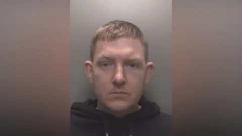Leicestershire Police A mugshot of Nathan Gothard. He is looking straight ahead and is wearing a black hoody.