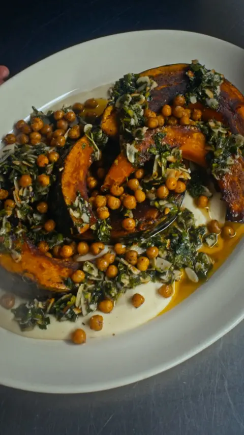 Roast squash chunks with garnish on a white plate