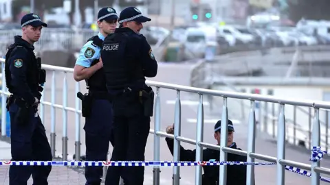 Getty Four police officers stand on a promenade at Bondi beach