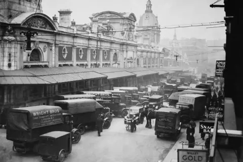 Getty Images Black and and white image of meat vans lined up on road outside Smithfield Market