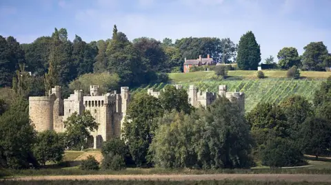 An image of Bodiam Castle, a 14th-century moated castle near Robertsbridge in East Sussex. Castle grounds can be seen in the backdrop of the image.