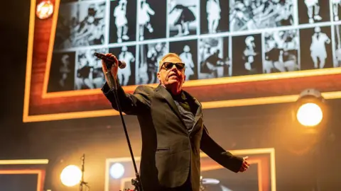 Suggs from Madness performing.
