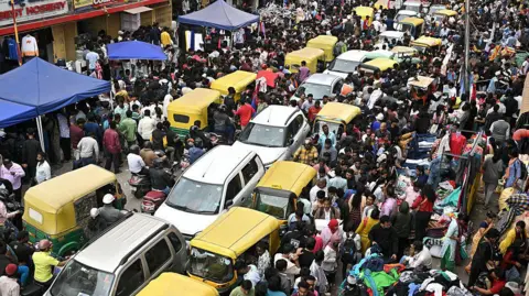 AFP via Getty Images Traffic jam at Chickpet market in Bengaluru on 11 January, 2026. Tuk-tuks, cars and swarms of people can be seen blocking a road. 