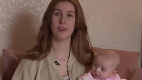 BBC Rachel Hargreaves sits on a sofa with her baby daughter Joni in her arms