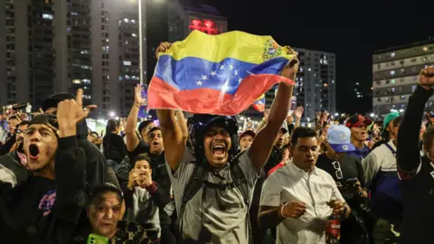 A man is holding a Venezuelan flag.