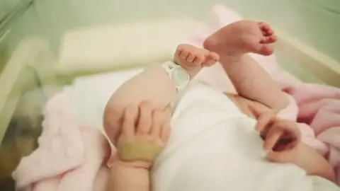 Getty Images View of a baby's hands and feet in an incubator