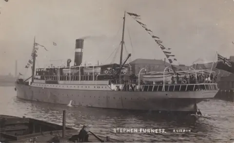 Bangor University A sepia image of the boat HMS Stephen Furness, cruising along a body of water. Bunting strung across and a Union Jack flag waving from the front of the ship.