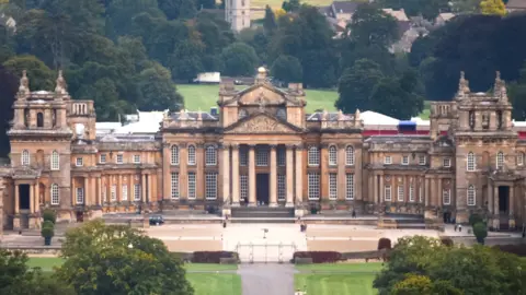 A wide shot of Blenheim Palace - including its large front façade complete with six grand columns. 
