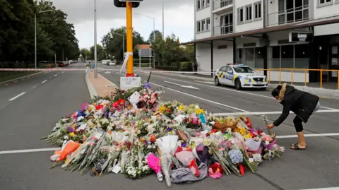 Flowers placed on a memorial in the centre of a road in Christchurch