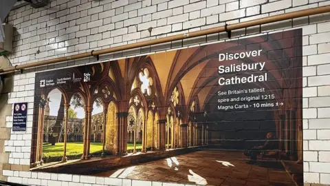 Subway tiled wall with large landscape photograph of Salisbury Cathedral telling people how to get there