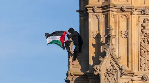 Reuters A man with a Palestinian flag sits on the Elizabeth Tower, commonly known as Big Ben.