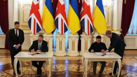 PA The leaders, with attendants next to them, sit at separate tables to signing the landmark agreement 