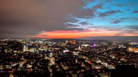 Ewan MacNeilage Edinburgh skyline lit up at night.