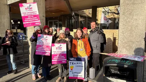 BBC UCU staff holding pink and white banners outside the University of Edinburgh on Monday.