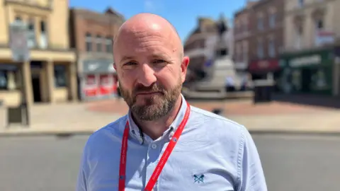 a man in a high street on a sunny day