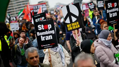 EPA Protesters carrying signs that read 'Stop bombing Iran' and 'No war on Iran'.