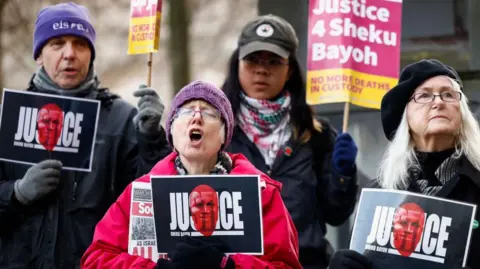 Getty Images Campaigners with placards holding a vigil outside Capital House in Edinburgh as the Sheku Bayoh Public Inquiry resumed in February, 2024 