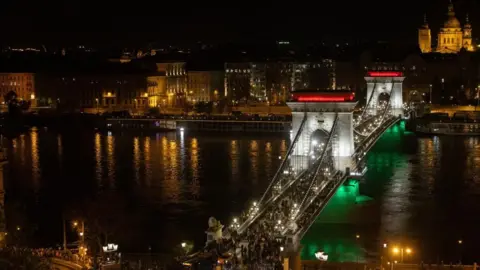 EPA The Chain Bridge, a landmark of the city of Budapest, is illuminated with the national colours during the night of the general elections in Budapest, Hungary, 12 April 2026.