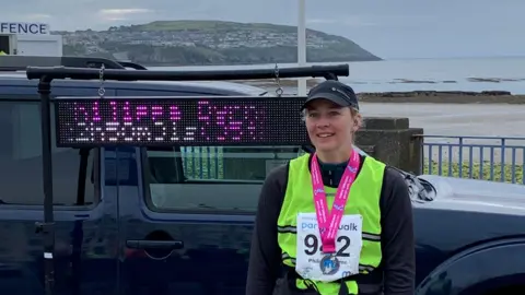PIPPA BYRNE Pippa Byrne wearing her bib and number for the 2024 Parish Walk with her finishers medal around her neck.