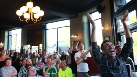 Reuters Crystal Palace cheer as they watch the FA Cup Final on a TV screen inside a pub.