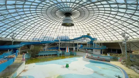 Seven Capital A recent photograph of the lagoon pool area shows murky green water, moult and crumbling surroundings, a bleak image under its famous domed roof