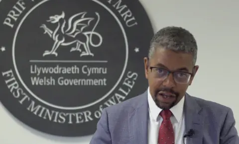 Vaughan Gething gives his resignation statement in front of Welsh government and First Minister of Wales logo