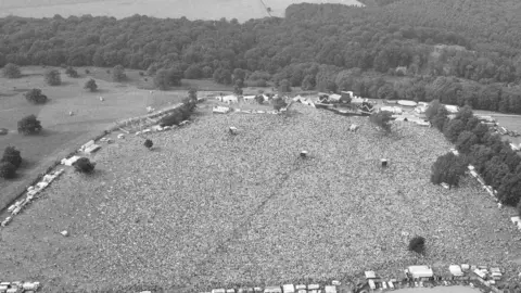 Getty Images A black and white photo, taken in a helicopter, shows the Queen concert at Knebworth with a huge crowd in front of a stage