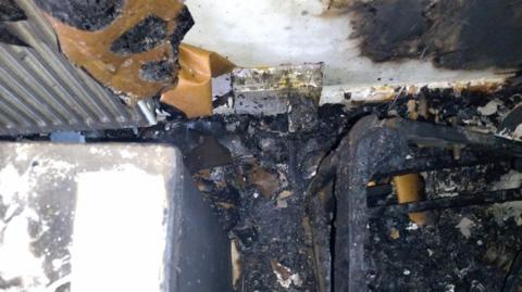 A bedroom severely damaged by fire in Basildon, Essex
