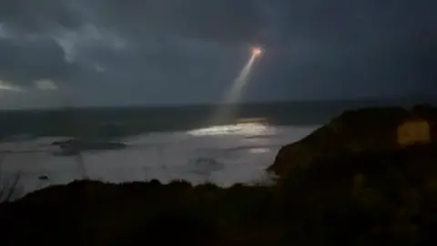 A helicopter with a strong search line flies over Newqyay 