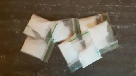 Nottinghamshire Police Eight square cellophane bags of white powder spread out on a table