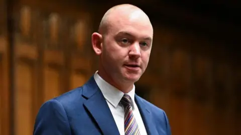 Andrew Snowden An image of the Fylde MP Andrew Snowden speaking in the House of Commons. He is wearing a blue suit, white shirt and multi-coloured tie.