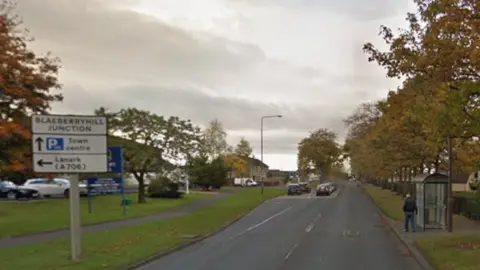 A google view of Main Street in East Whitburn with a man standing at a bus stop