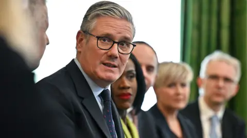 Keir Starmer in a cabinet meeting at Downing Strreet  looking stressed. 