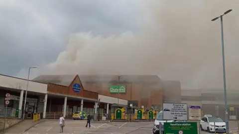 Terry Francis Smoke rising from Dunelm store in front of car park