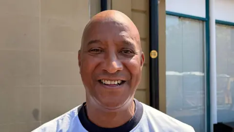 A close up photo of Eddie who is smiling and wearing a t-shirt. 