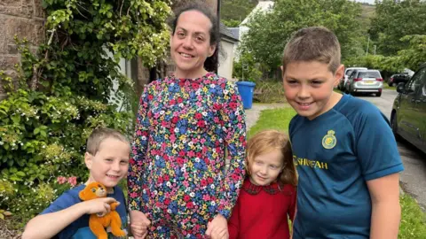Katy Campbell and three of her five children outside their home in Ullapool