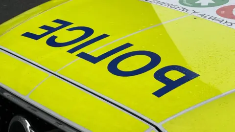 A generic picture of the top of a police car bonnet. The word police can be seen and some other wording including "emergency always". 