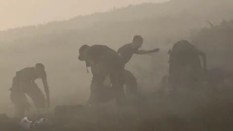 Derbyshire Fire and Rescue Service Firefighters viewed through a miasma of smoke