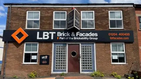 A building with a sign for LBT Brick and Facades