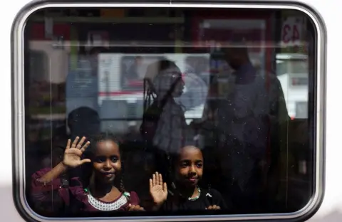 MOHAMED ABD EL GHANY / REUTERS Two children on board a train stand at the window and wave.